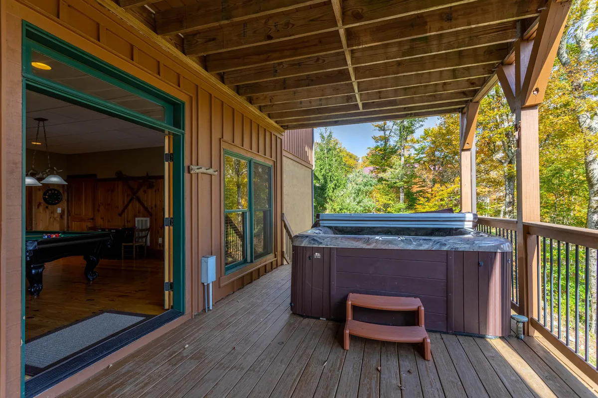 This image features a hot tub nestled on a spacious deck surrounded by trees, offering tranquil mountain views. The deck area provides a cozy spot for relaxation and is ideal for soaking in the natural beauty while enjoying the hot tub. The setting feels private and inviting, perfectly capturing the allure of outdoor living at Buckhorn Lodge.